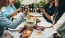 a group of people having a meal around an outdoor table